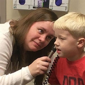 Nurse examining child's ear