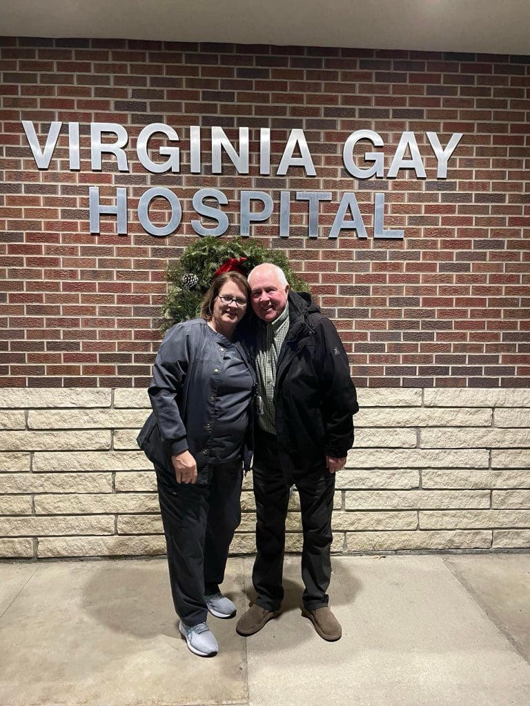 Lori Clark and man standing in front of Virginia Gay Hospital